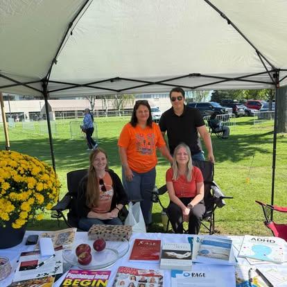 Four Sheila Tallon & Associates team members at our information table at the 2026 Akwesasne Powwow